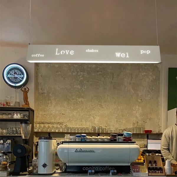 Yazı kesimli linear LED sarkıt avize modeli, uzun metal gövdeli kafe tezgâhı ve bar aydınlatması